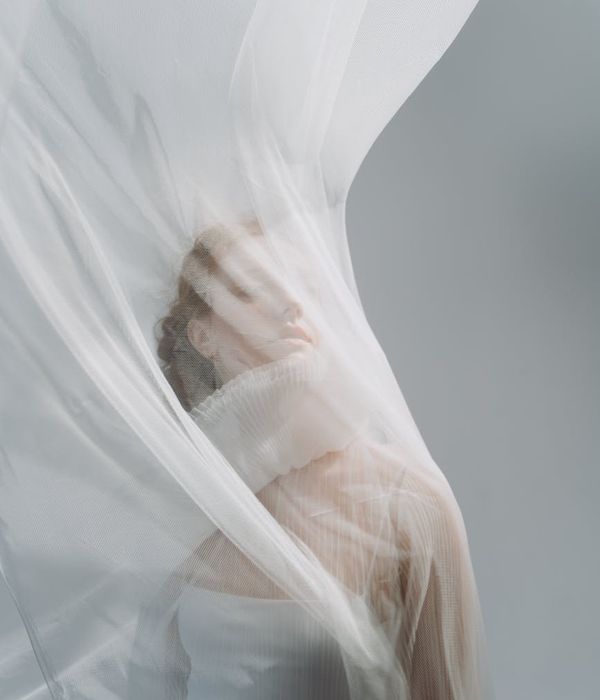 Woman performing a gentle, flowing movement in a brightly lit studio.